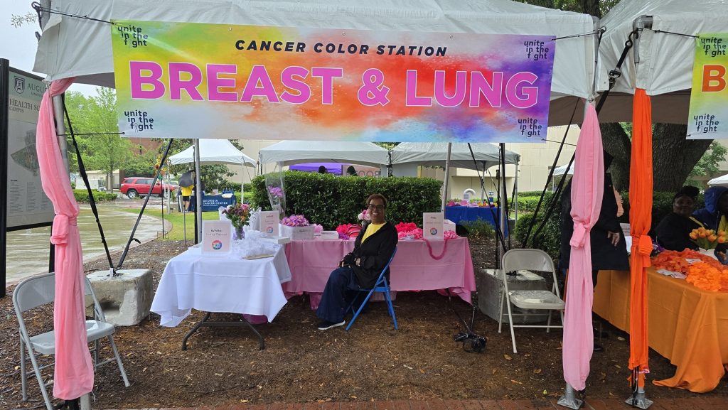 In this photo, you see people posing for a photo under a tent.