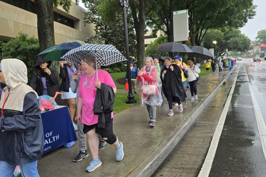 In this photo, you see people walking down a sidewalk. They are participants in the Georgia Cancer Center's Unite in the Fight Against Cancer 2026 community event.