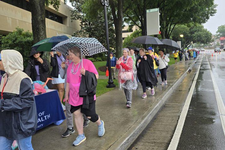In this photo, you see people walking down a sidewalk. They are participants in the Georgia Cancer Center's Unite in the Fight Against Cancer 2026 community event.