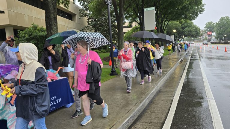 In this photo, you see people walking down a sidewalk. They are participants in the Georgia Cancer Center's Unite in the Fight Against Cancer 2026 community event.