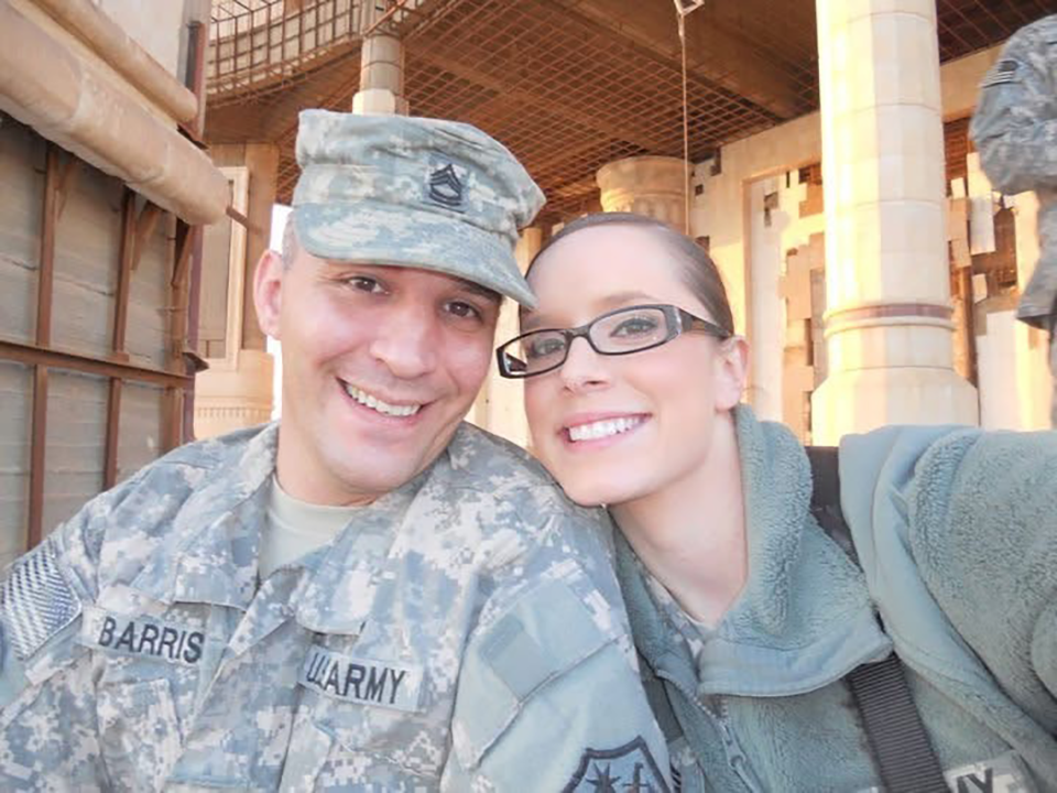 A man and woman in army uniforms smiling while taking a selfie.