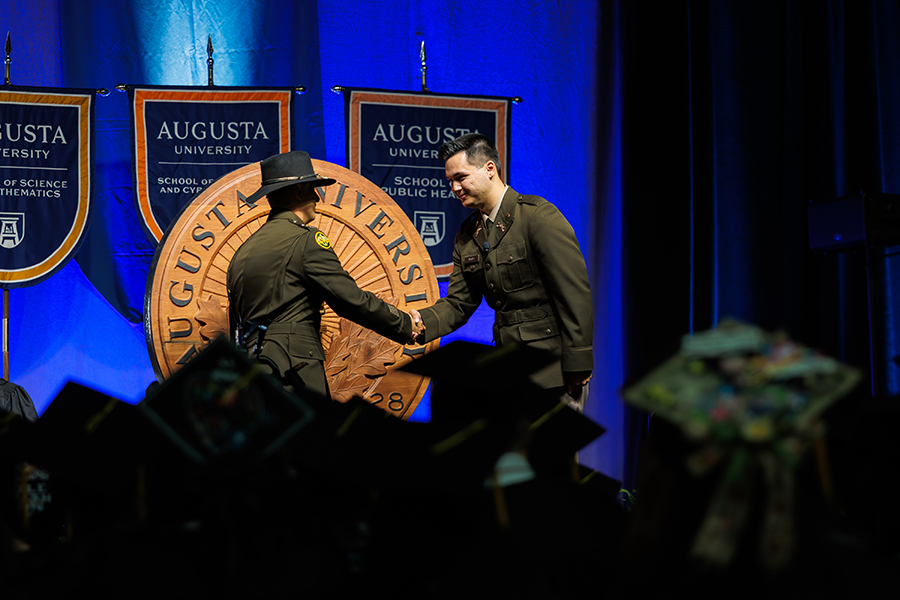 two men in military uniforms shaking hands on stage 