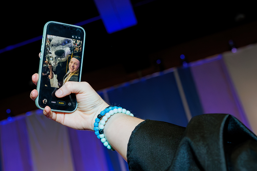 a female student takes a selfie with a cat mascot