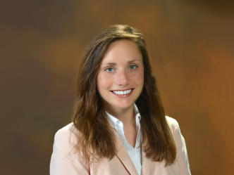 A woman wearing a suit poses for a picture.