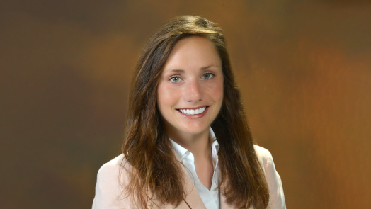 A woman wearing a suit poses for a picture.