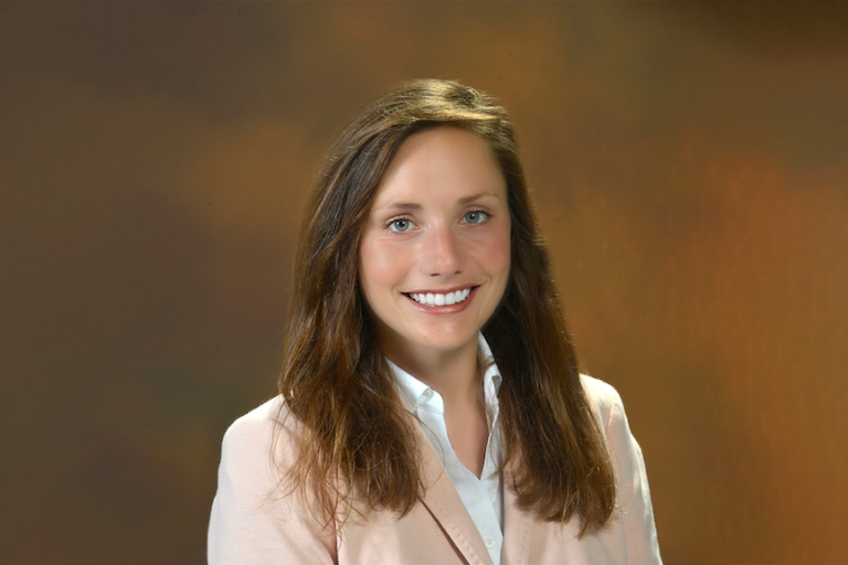 A woman wearing a suit poses for a picture.