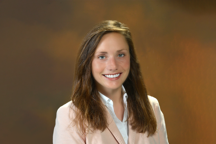 A woman wearing a suit poses for a picture.