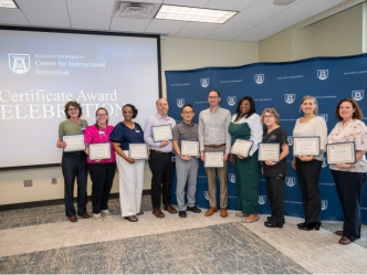 Group of men and women standing together and holding certificates.