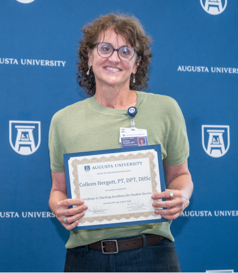 Woman wearing glasses holding a certificate.