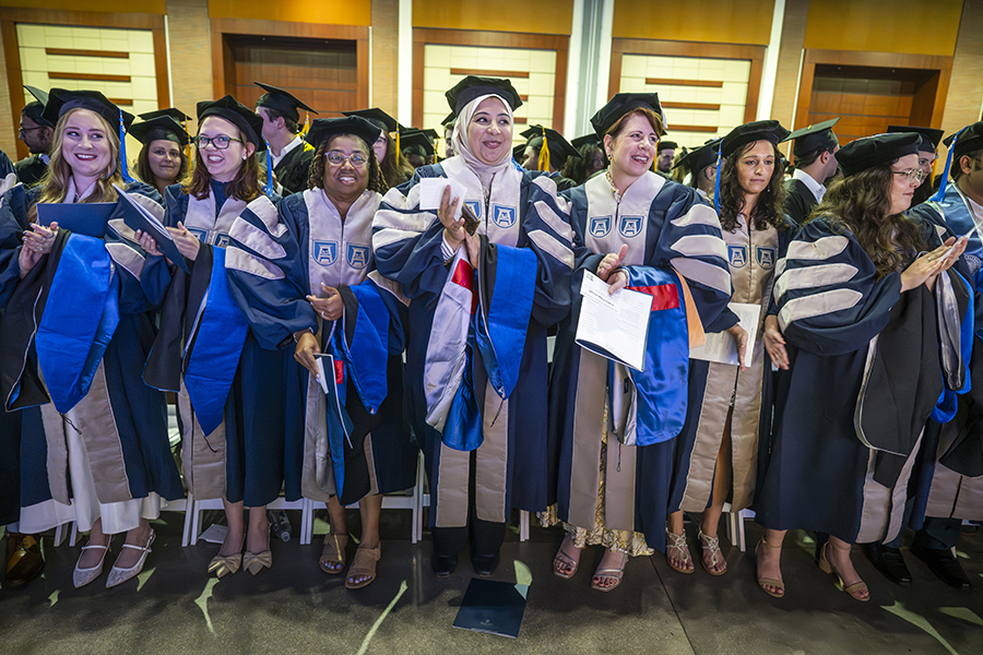 a group of female students wearing blue and gray graduation robes 