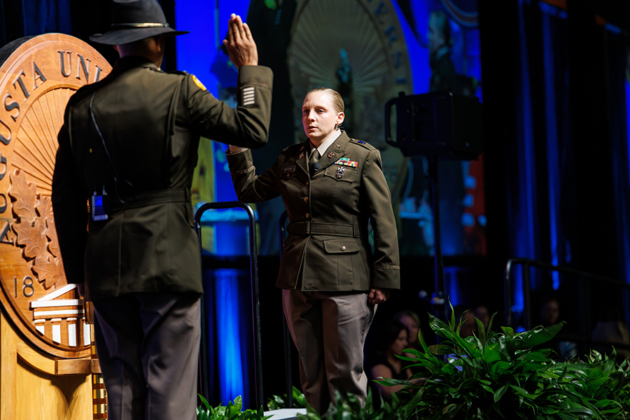 a female in a military uniform raising her hand 