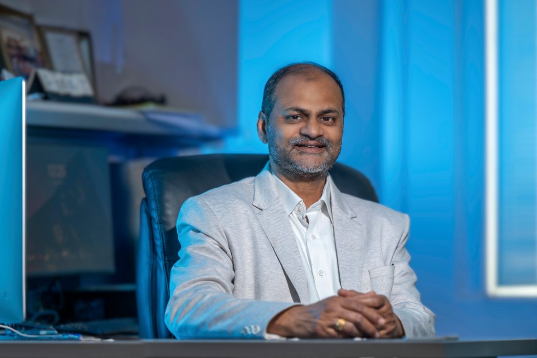 Man sitting in a suit at a desk.