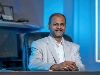 Man sitting in a suit at a desk.