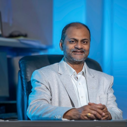 Man sitting in a suit at a desk.