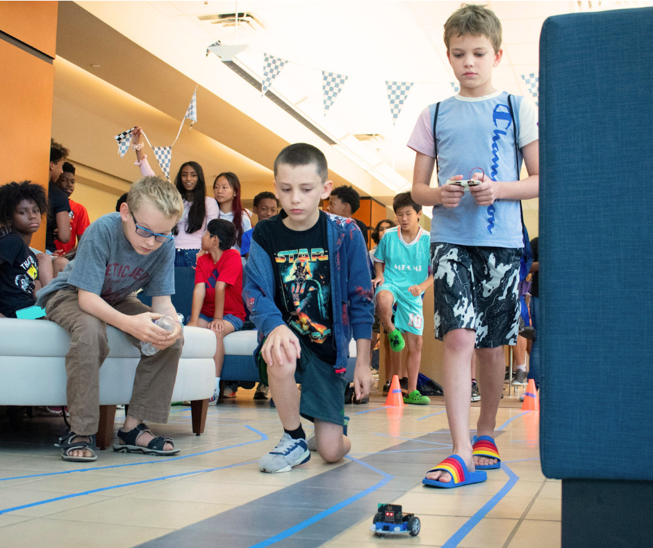 Student teams work together to control the movement of a Micro:bit Cutebot during the Grand Prix race on the final day of the VICEROY Kids Coding Camp.