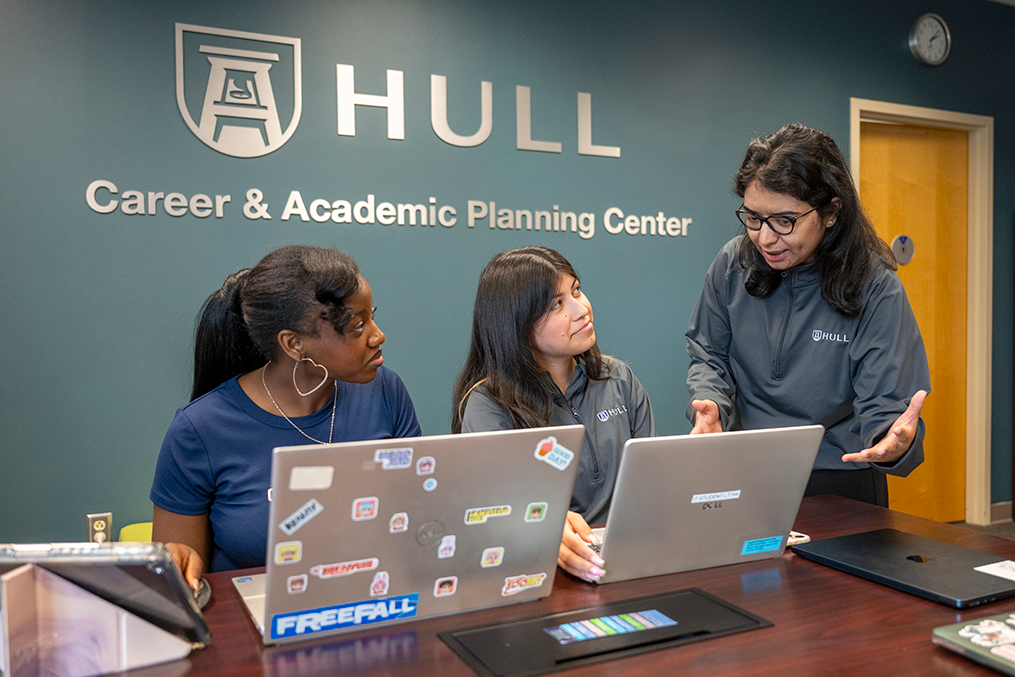 3 female students look at laptops