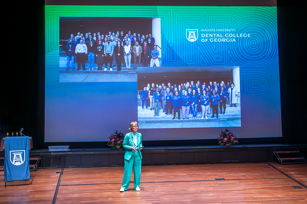 former dean of Dental College of Georgia in front of large screen on a stage