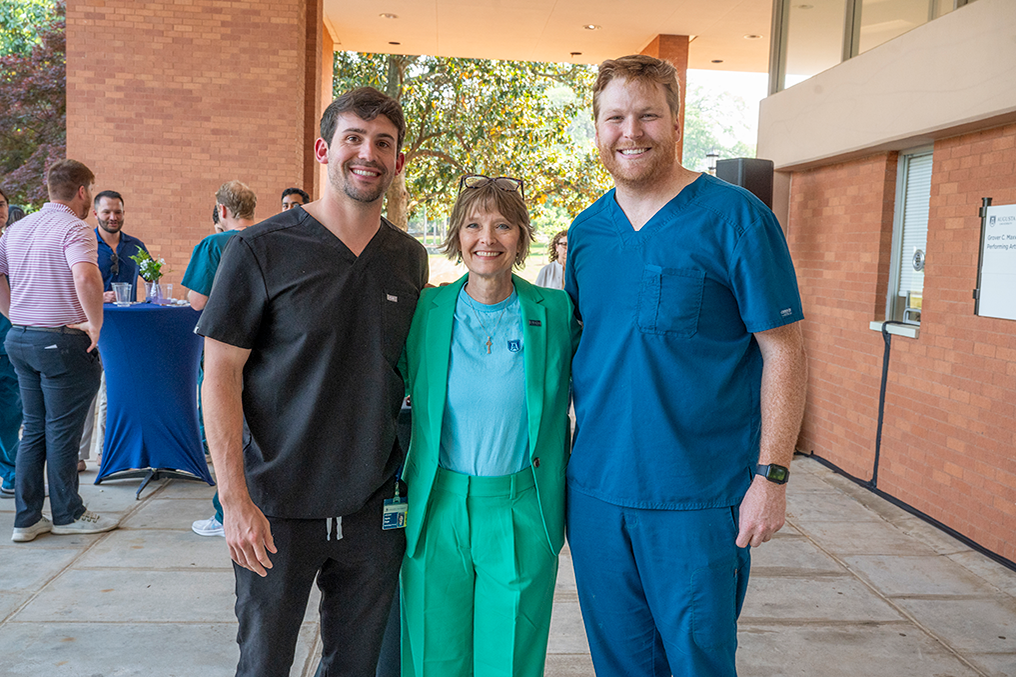 former dean of Dental College of Georgia with two students in scrubs