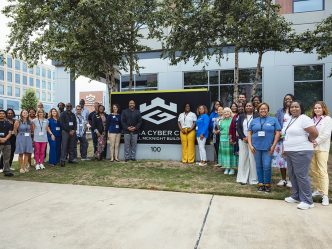 A group of men and women in front of a sign