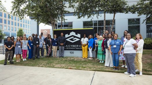 A group of men and women in front of a sign