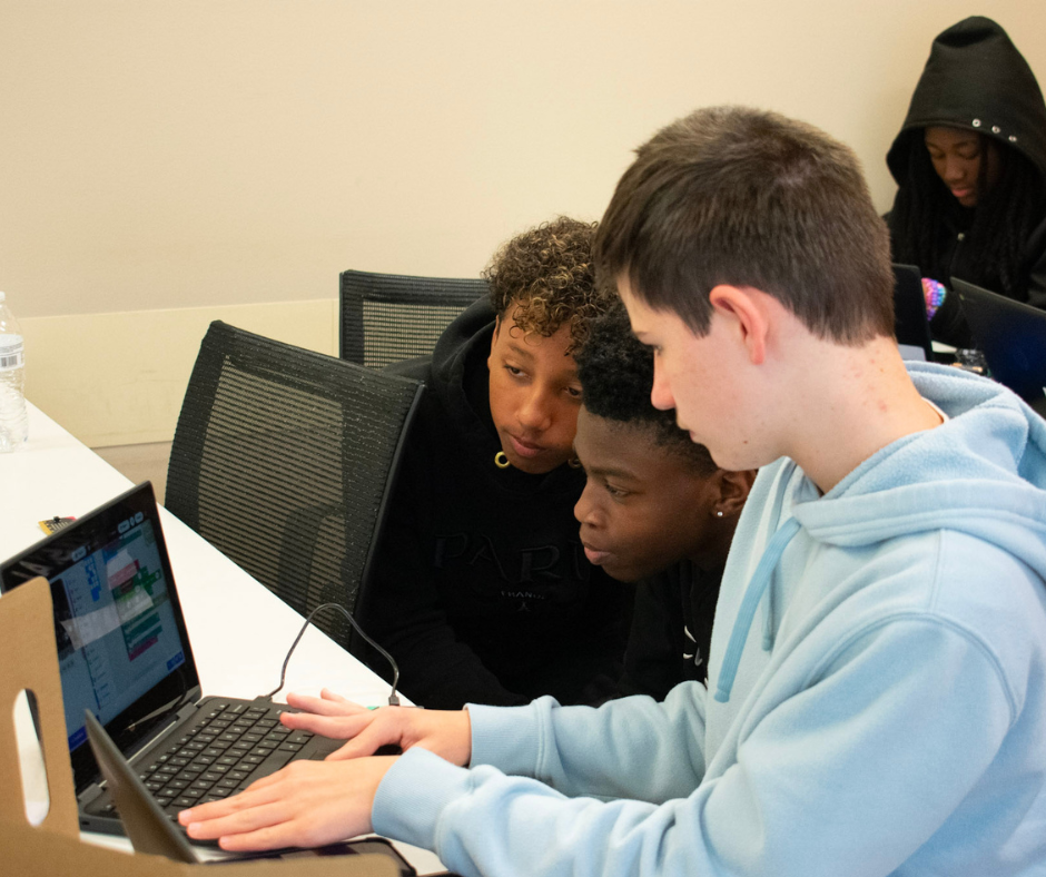Students work together on laptops to code micro:bit Cutebots during the VICEROY Kids Coding Camp.