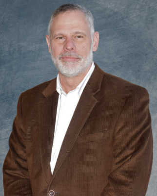 Man poses for photo in front of backdrop