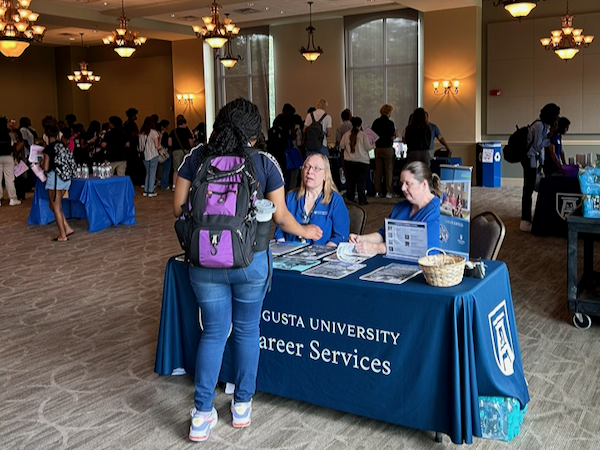 A ballroom full of people at a career fair. 