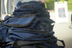 Photo of several backpacks sitting on table outside