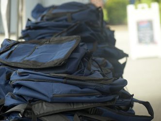 Photo of several backpacks sitting on table outside