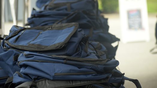 Photo of several backpacks sitting on table outside