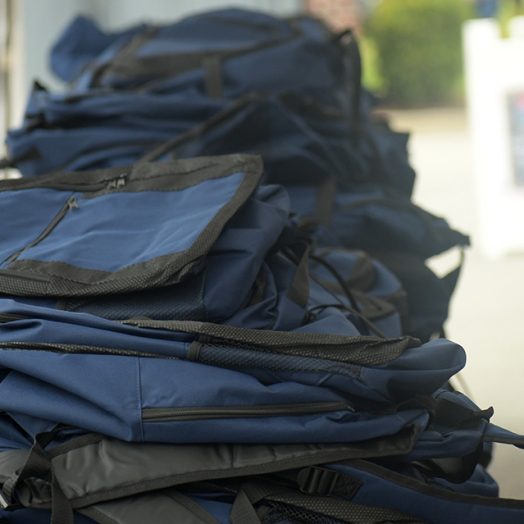 Photo of several backpacks sitting on table outside