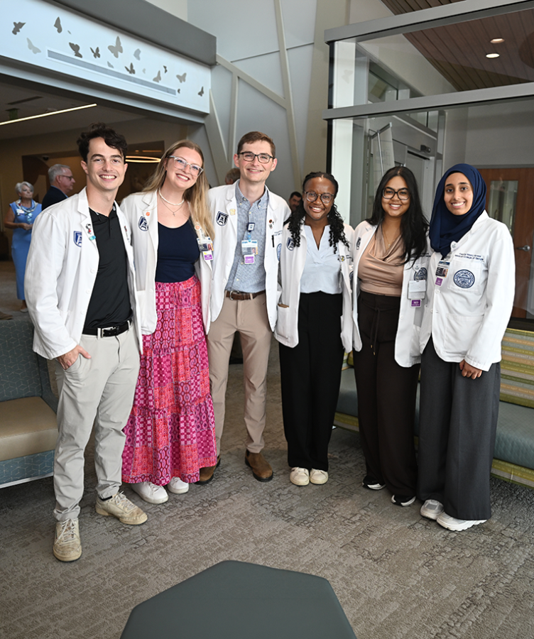 Young men and women in medical white coats.