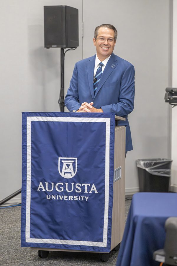 Man standing behind a podium smiling