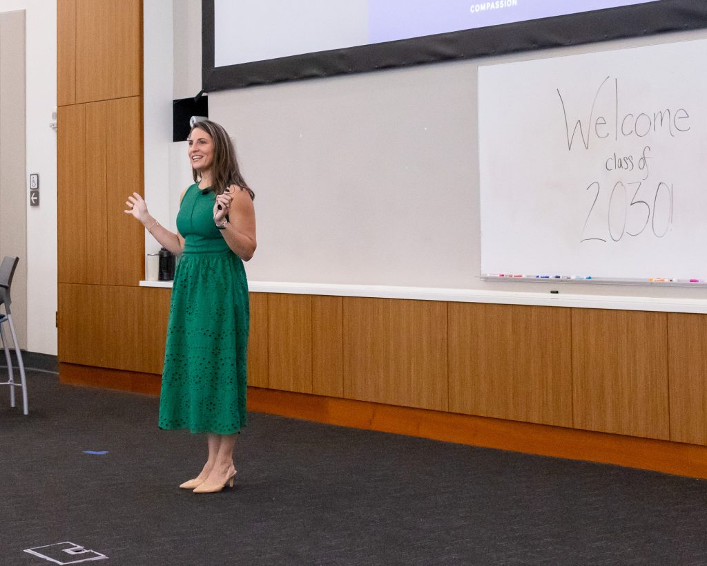 Woman stands in front of large white board