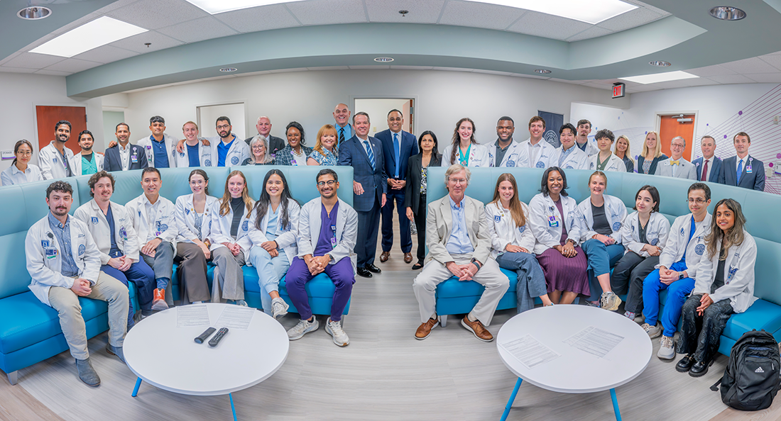 Large group of men and women in business dress and medical students in white coats