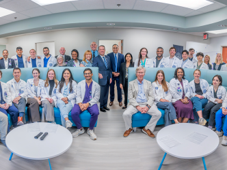 Large group of men and women in business dress and medical students in white coats