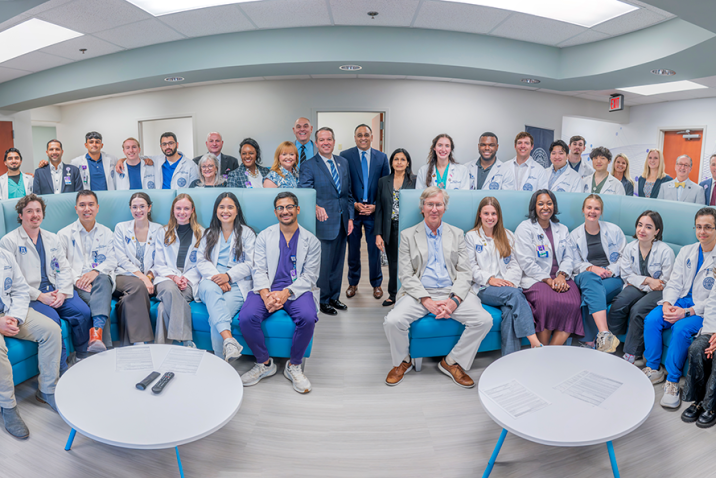 Large group of men and women in business dress and medical students in white coats