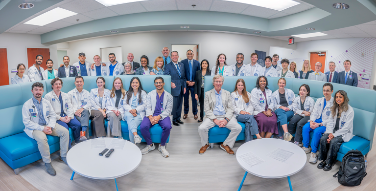 Large group of men and women in business dress and medical students in white coats