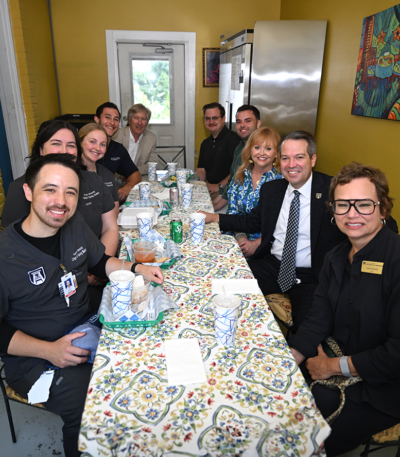 Men and women, some in medical scrubs, seated at a table