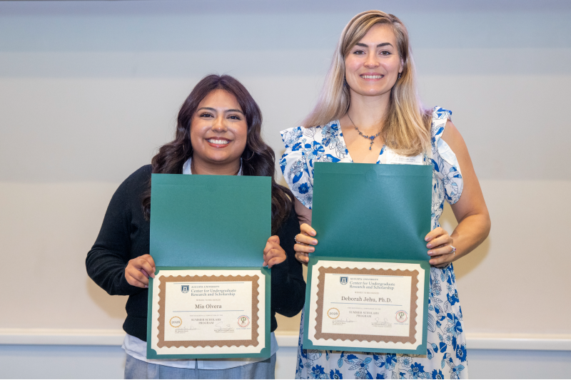two women standing next to each other holding certificates