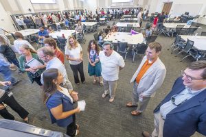group of people standing and talking to each other.
