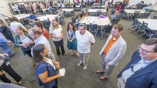 group of people standing and talking to each other.
