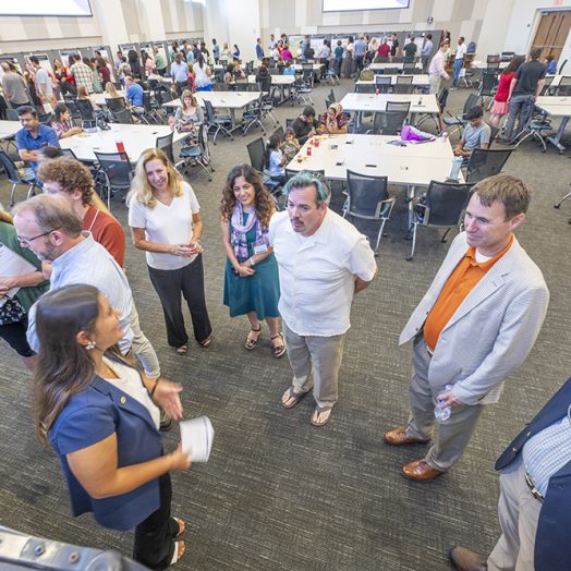 group of people standing and talking to each other.