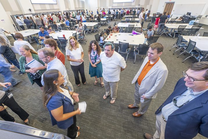 group of people standing and talking to each other.