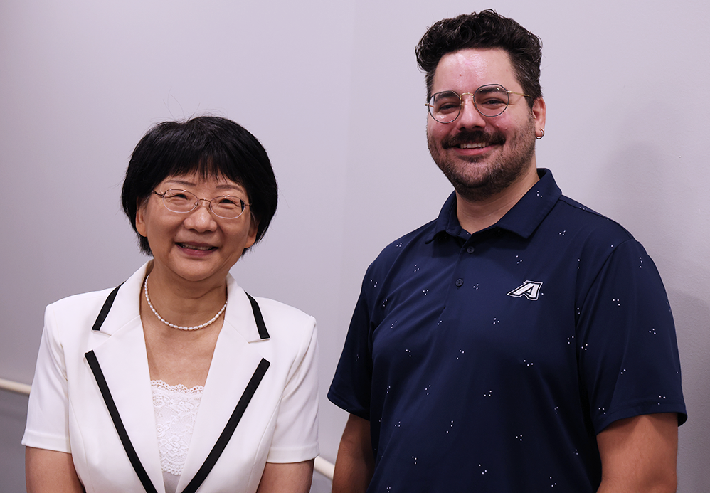 A man and a woman smile at the camera.