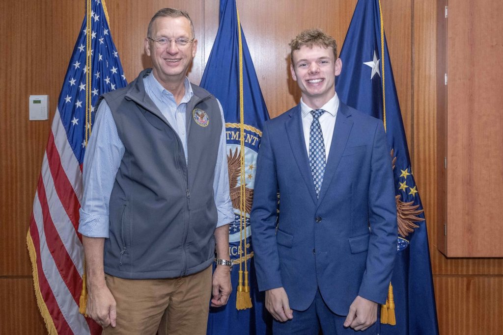 Two men standing by flags 