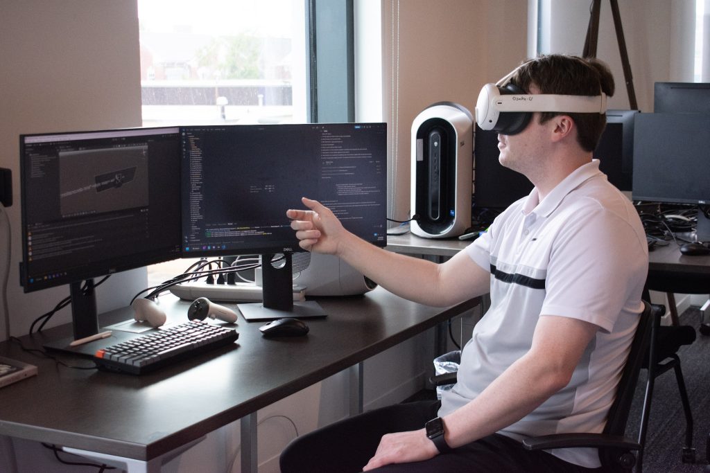Student at desk working on project with meta goggles.