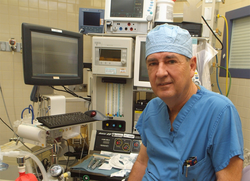 man in scrubs and cap with medical equipment