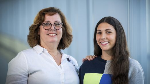 Two women smiling while posing for a photo