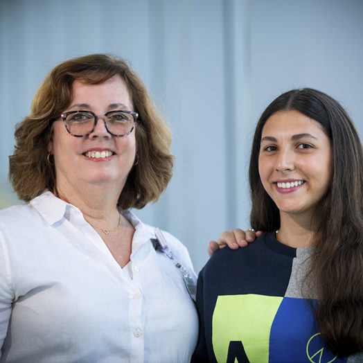 Two women smiling while posing for a photo